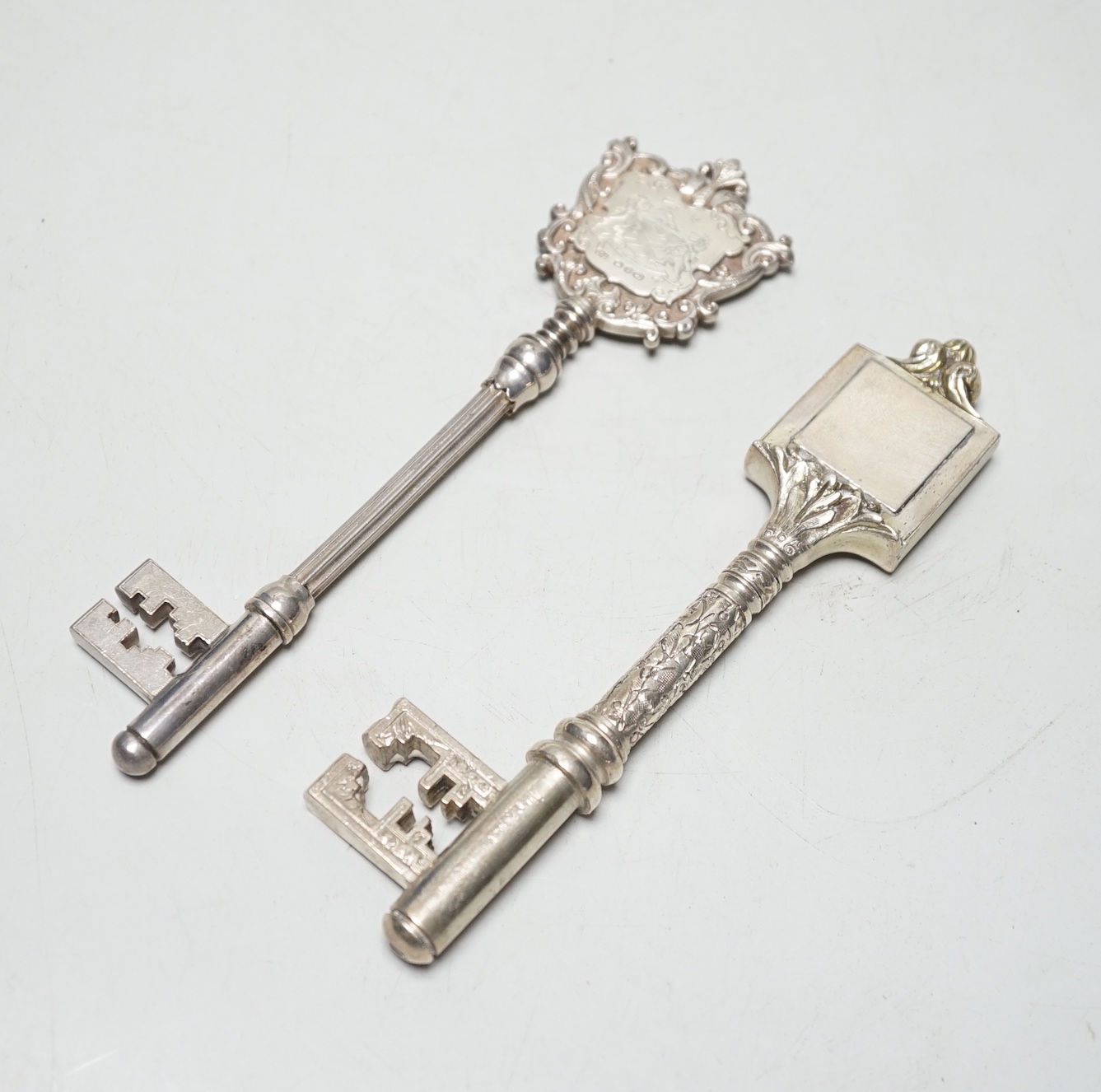 A late Victorian silver presentation key, with engraved armorial, James Fenton & Co, Birmingham, 1897, 16.9cm, 3.2oz and a similar silver plated key.